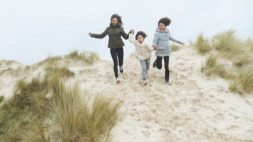 Visitors playing and running on the dunes